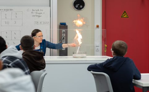 Lehrerin C. Güttner zeigt die Flamme